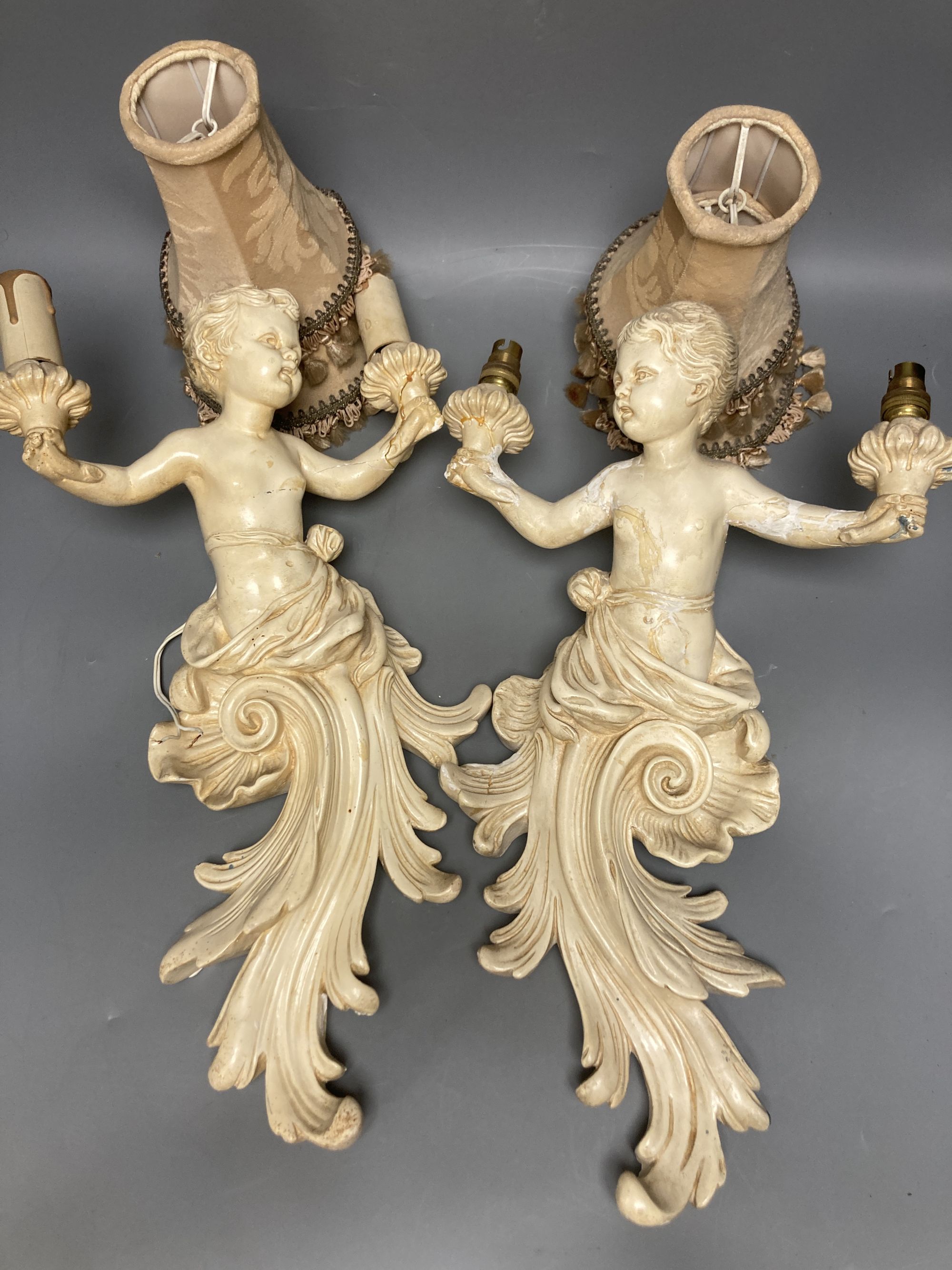 A pair of cream painted wood cherub wall lights, length 43cm